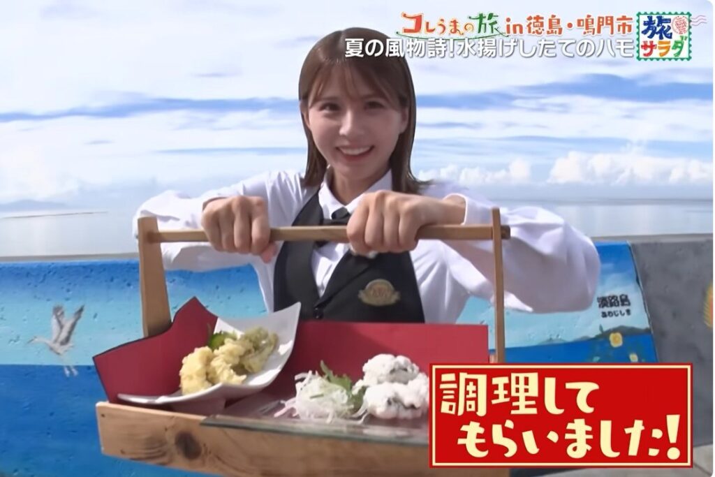 番組の画面。ハモの天ぷらと湯引きを盛った器を持つリポーター。字幕は「調理してもらいました！」