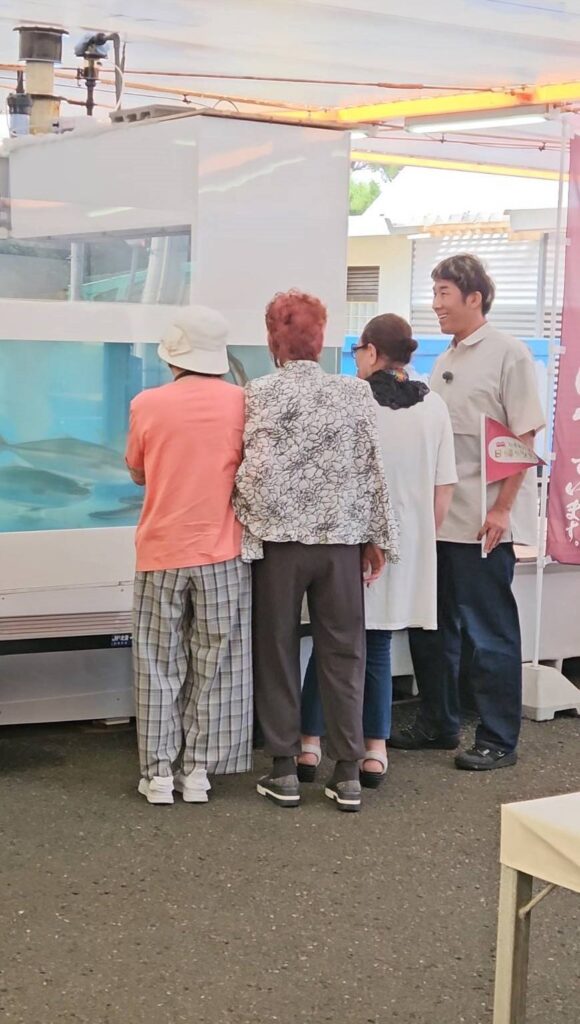 さかな市の水槽をのぞく出演者のみなさん
